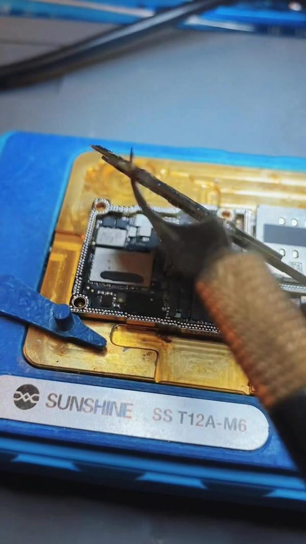 Mikrolötarbeit mit Heißluft an einem iPhone-Mainboard auf einer Sunshine-Platinenhalterung